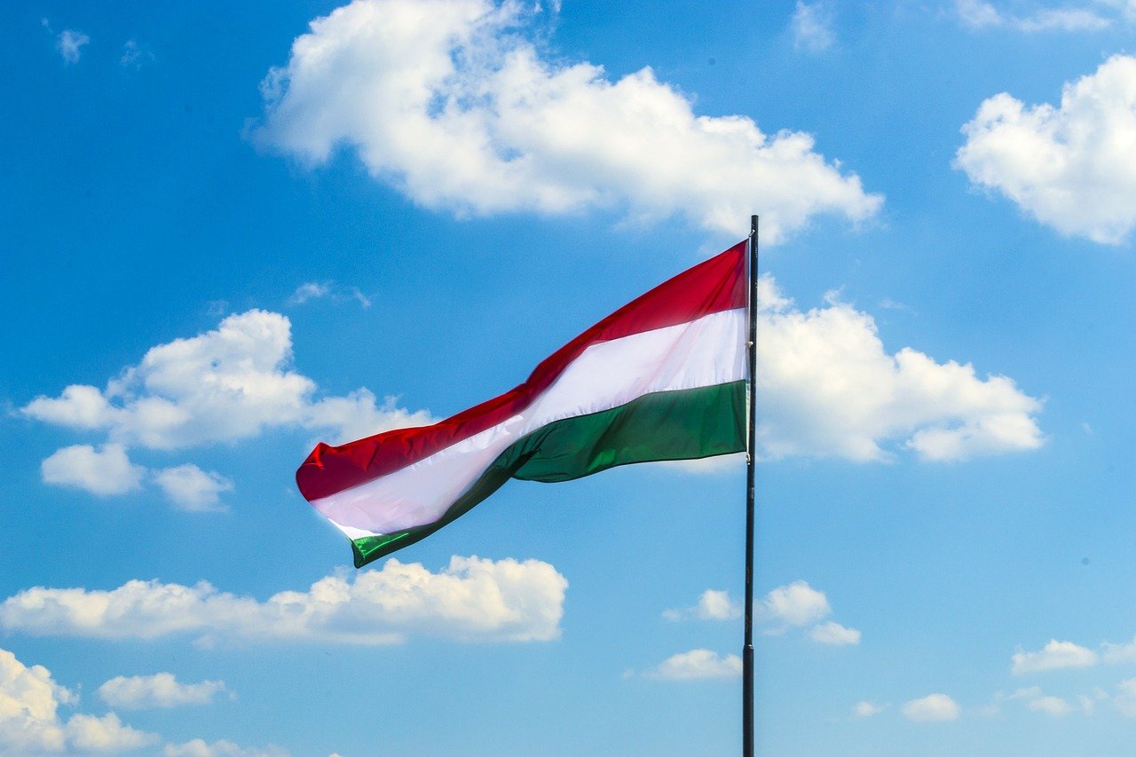 Hungary's flag flying against a blue sky