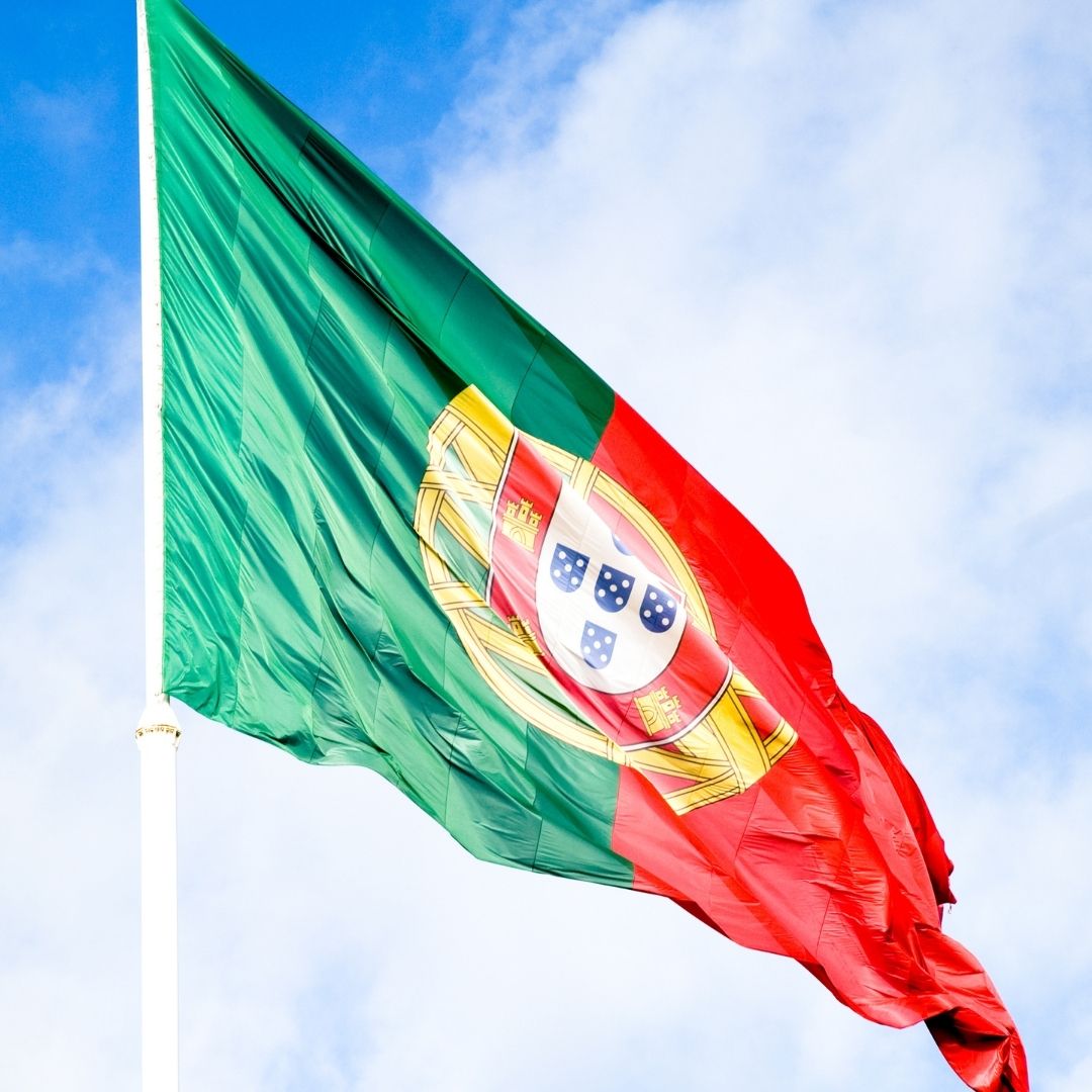 portugal flag flies against a blue sky