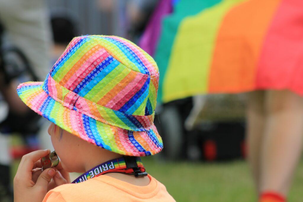 A child with a hat in rainbow colors