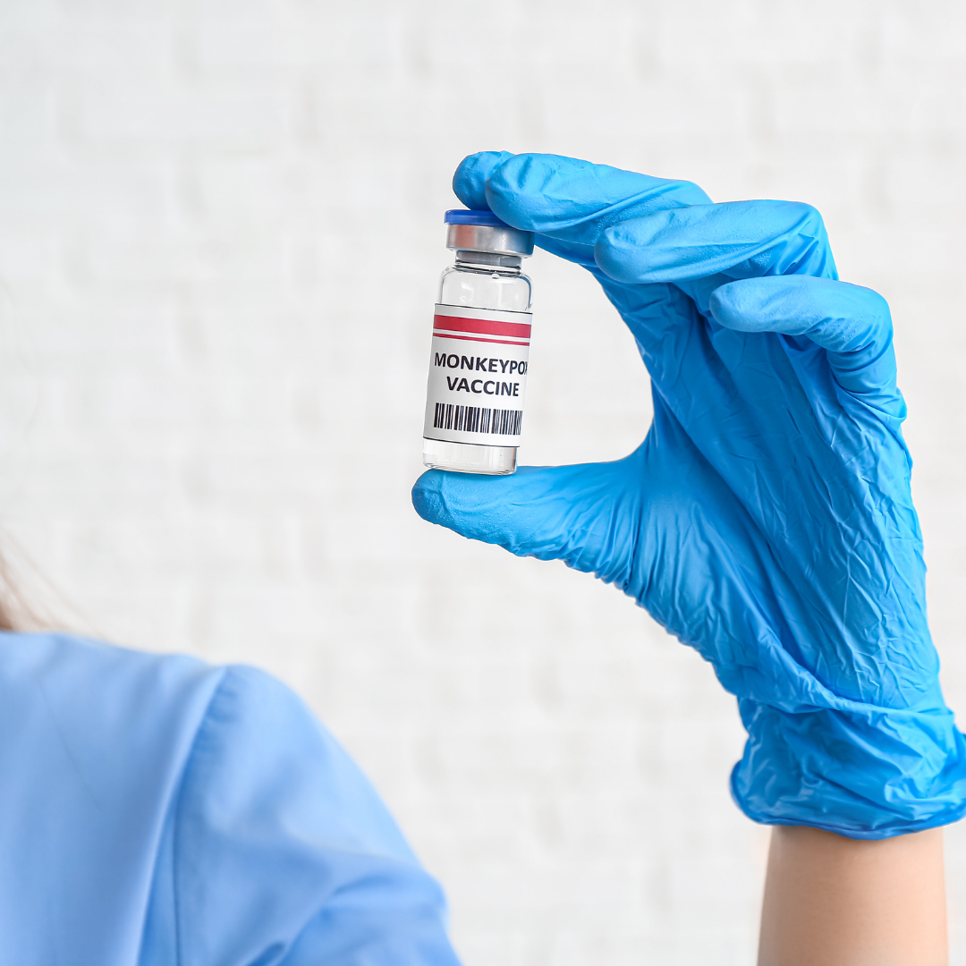 A hand in a blue glove holding a monkeypox vaccine dose recipient